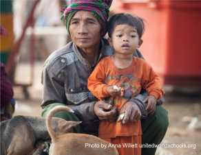 Man and small child with dogs, Cambodia (Photo by Anna Willett) unitedworldschools org